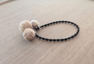 ちいさなベージュ系の毛の球が３つついたヘアゴム